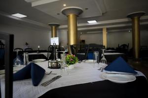 a table with a white table cloth and blue napkins at Mansea Beach Hotel in Kololi