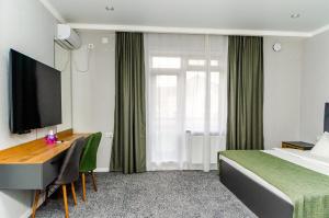 Un pat sau paturi într-o cameră la Dosman Hotel Bishkek