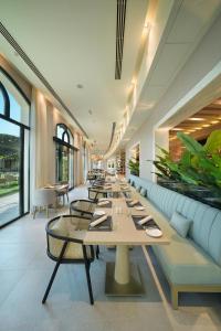 a long dining room with a long table and chairs at Al Ain Rotana in Al Ain