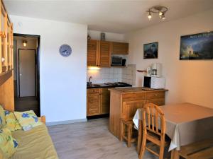 a kitchen and dining room with a table and a couch at Appartement 2 pièces cabine, 100m pistes, parking gratuit - FR-1-297-127 in Auris