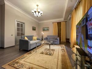- un salon avec un canapé, une table et une télévision dans l'établissement Old City apartment, à Baku