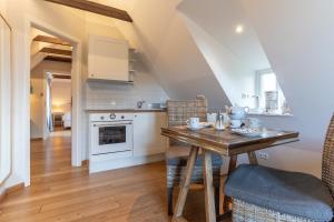 a kitchen with a table and chairs in a room at Fischerhaus am Strand Appartement Kuschelnest in Brösum