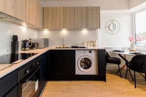 a kitchen with a washing machine in the middle at Stirling Redhill by Pay As U Stay in Redhill