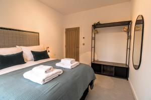 um quarto com uma cama com toalhas em Stirling Redhill by Pay As U Stay em Redhill