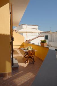einen Balkon mit einem Tisch und einem Sonnenschirm in der Unterkunft Arcadia Case e Vacanze in Ischia