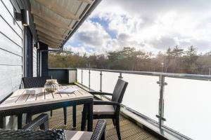 a patio with a table and chairs on a balcony at Penthouse Penthouse Skipperhuset in Sankt Peter-Ording