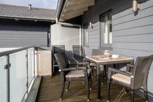 a patio with a table and chairs on a balcony at Penthouse Penthouse Skipperhuset in Sankt Peter-Ording