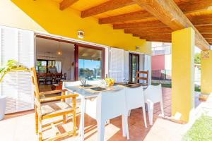 una sala da pranzo con tavolo e sedie bianchi di Villa Ibiza Alcudia Mallorca a Alcudia
