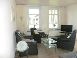 een woonkamer met 2 stoelen en een televisie bij Ferienwohnung Plett in Barlt