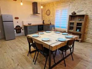 una cocina con una gran mesa de madera en una habitación en Gîte « domaine de l’oustal nau », en Peyriac-de-Mer