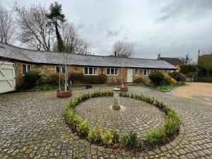 a brick house with a stone circle in front of it at Charming Pretty cottage in Banbury