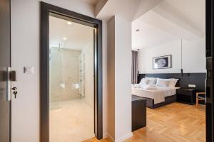 a bedroom with a bed and a glass door leading to a bathroom at Miramare Hotel in Zadar