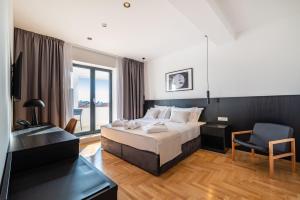 a hotel room with a bed and a chair at Miramare Hotel in Zadar