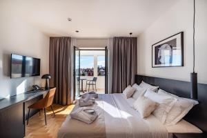 a bedroom with a large bed with a desk and a desk at Miramare Hotel in Zadar