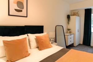 a bedroom with a bed with orange pillows at Redhill Apartments by Pay As U Stay in Redhill