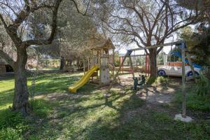 un parc avec une aire de jeux avec un toboggan et une voiture dans l'établissement #FLH - Amalthia & Αthena Beachfront Houses in Pefkohori, à Pefkohori