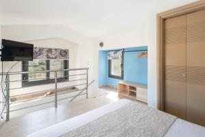 a bedroom with a bed and a flat screen tv at #FLH - Amalthia & Αthena Beachfront Houses in Pefkohori in Pefkohori