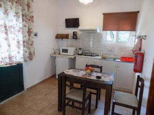 a small kitchen with a table and chairs and a counter at villa elli panoramic view 2 in Ipsos