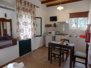 una pequeña cocina con mesa y sillas. en villa elli panoramic view 2, en Ýpsos