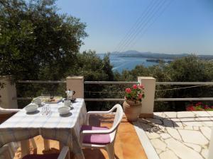 una mesa y sillas en un patio con vistas al agua en villa elli panoramic view 2 en Ypsos