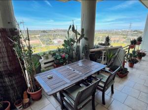 uma mesa de madeira e cadeiras numa varanda com plantas em Sweet house em Bari