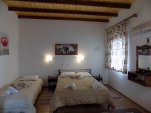 a bedroom with two beds and a wooden ceiling at villa elli panoramic view 2 in Ýpsos