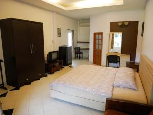 1 dormitorio con 1 cama grande y TV en Pala-U Garden Home (Time Pala-U), en Ban Pa Lau