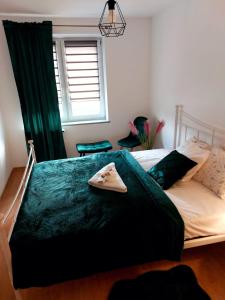 Un dormitorio con una cama con una manta verde. en Apartament Mar&Mel, en Głuchołazy