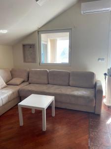 a living room with a couch and a table at Apartman Jaca in Mrčevac