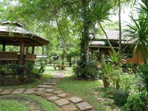 einen Garten mit einem Haus und einem Pfad in der Unterkunft Pala-U Garden Home (Time Pala-U) in Ban Pa Lau