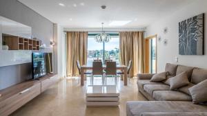 a living room with a couch and a dining room table at Marina Vilamoura Aquamar 220 By Vilamoura Sun in Quarteira
