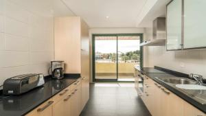 a kitchen with a sink and a counter top at Marina Vilamoura Aquamar 220 By Vilamoura Sun in Quarteira