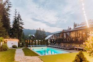 a resort with a swimming pool and a building at Hotel Vedmezhyi Dvir in Bukovel