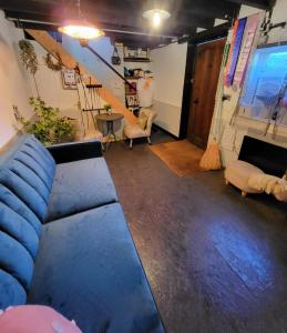 a living room with a blue couch and a staircase at The Stable Annexe & Spa in Dogdyke