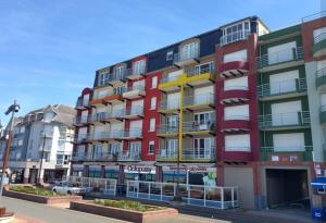 un edificio alto con balconi colorati su una strada di Face à la mer Corinne a Mers-les-Bains