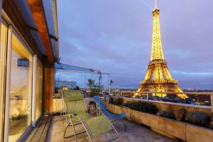 - un balcon avec deux chaises et la tour Eiffel dans l'établissement Appartement Lagny sur Marne DisneyLand Paris, à Lagny-sur-Marne