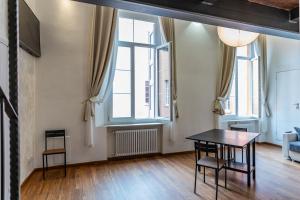 a living room with a table and two windows at Solmi Home in Modena +20 photos