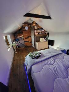 - une chambre mansardée avec un grand lit violet dans l'établissement The Stable Annexe & Spa, à Dogdyke