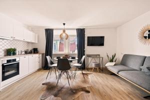 cocina y sala de estar con mesa y sillas en Einzimmerwohnung in Seenähe klimatisiert, en Friedrichshafen