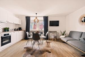 a kitchen and living room with a table and chairs at Einzimmerwohnung in Seenähe klimatisiert in Friedrichshafen