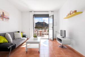 a living room with a couch and a tv at Las Hélices San José Cabo de Gata in San José