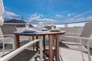 a wooden table with wine glasses on a balcony at Las Hélices San José Cabo de Gata in San José