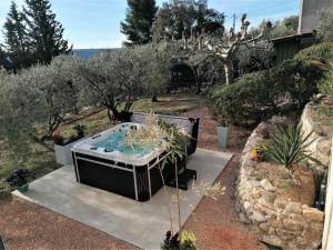 a hot tub in the middle of a garden at Chambre d'hôtes et Spa en Luberon in Volx +32 photos
