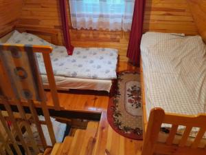 um quarto com uma cama, uma cadeira e um berço em Domek Leśny Klimat em Serpelice