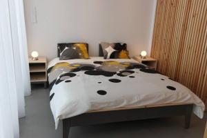 a bed with a black and white comforter and pillows at Designer loft in heart of Athens nightlife in Athens