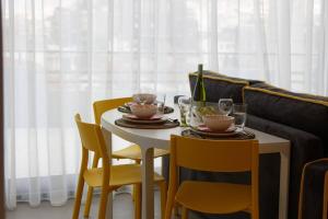 雅典的住宿－Designer loft in heart of Athens nightlife，餐桌、两把椅子、一张白色桌子和两杯