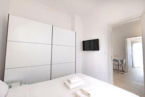 a white bedroom with a large mirror and a tv at Athens Tower 2 Bedroom Apartment by SuperHost Hub in Athens