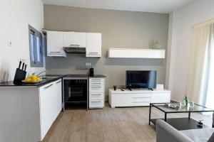 a kitchen with white cabinets and a living room at Athens Tower 2 Bedroom Apartment by SuperHost Hub in Athens