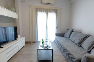 uma sala de estar com um sofá e uma televisão em Athens Tower 2 Bedroom Apartment by SuperHost Hub em Atenas