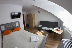 een woonkamer met een bed en een bank bij Pokoje u Mirka in Dźwirzyno